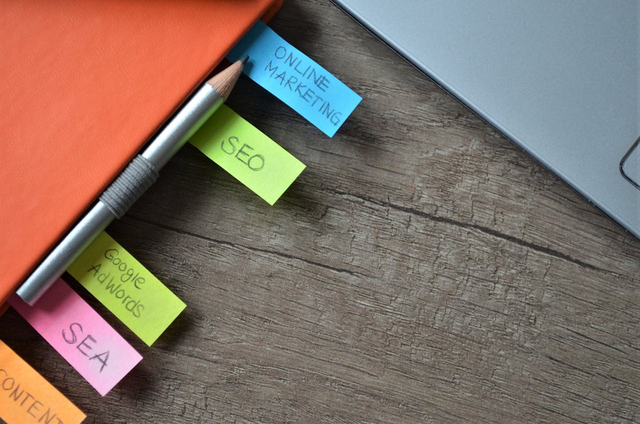 Close-up of SEO strategy planner with colorful sticky notes and a pencil on a notebook.